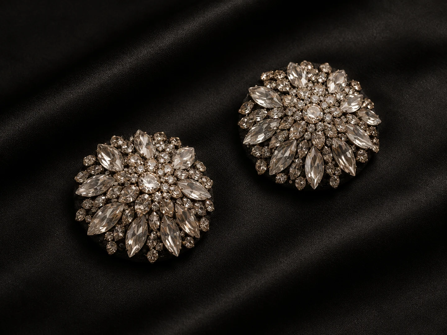 A pair of champagne and clear crystal nipple-cover design concepts on dark satin. AI-generated illustration, not a manufactured product.